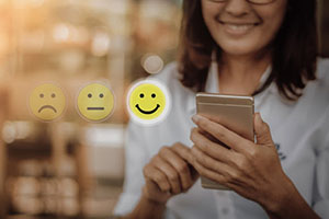 smiling woman holding a phone, the photo shows emoticons sad and indifferent translucent, cheerful focused